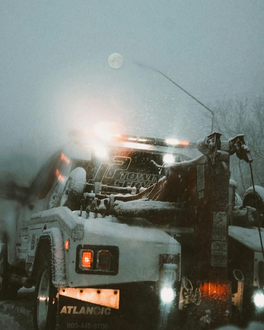 a-truck-driving-down-a-snow-covered-road-t4ab5hcxinc