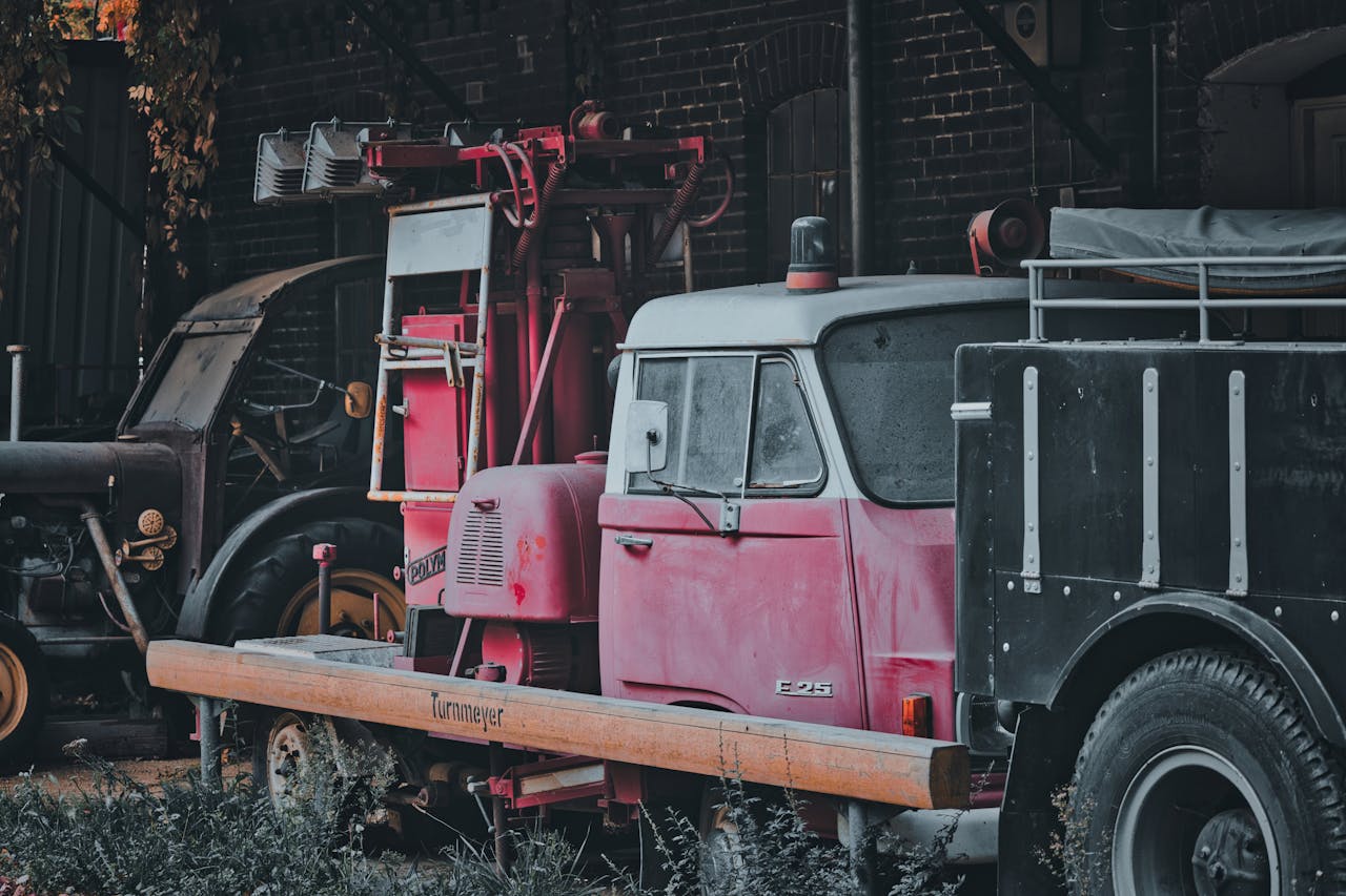 A nostalgic red fire truck parked in a rustic barn, capturing a historical and retro vibe.